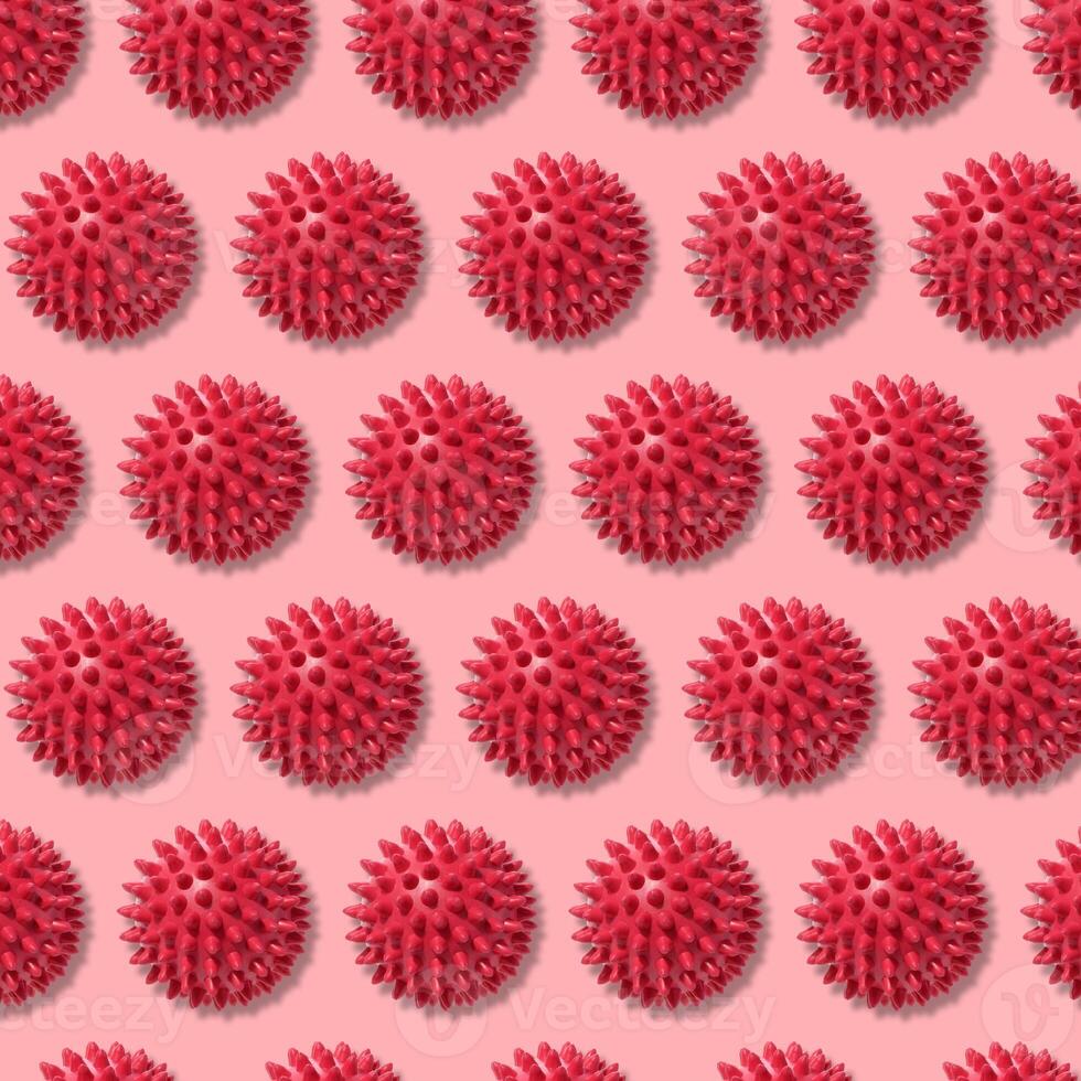Round red ball with spikes, animal toy or massager. Repeating pattern photo