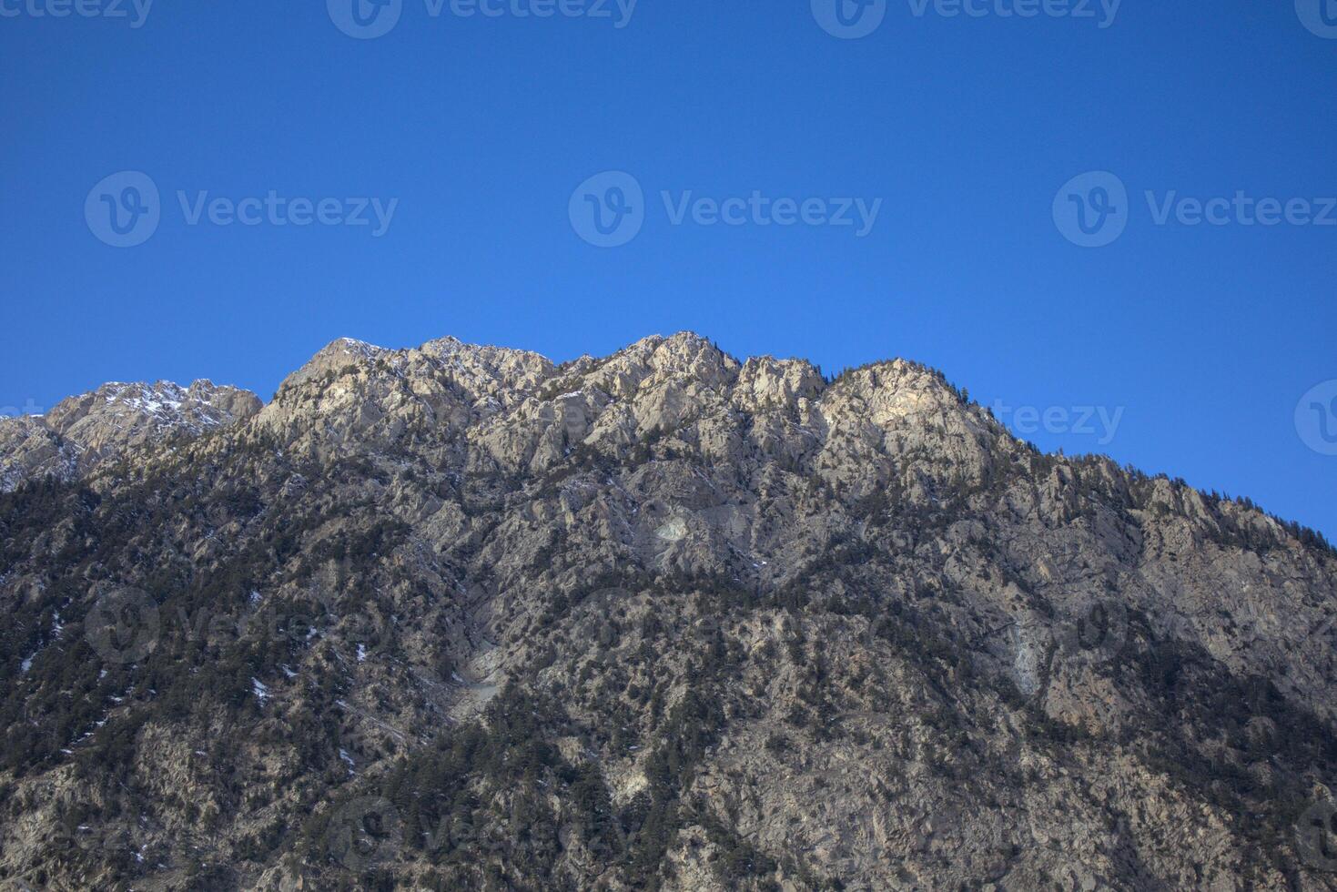 Rugged Mountain Peak Against a Vibrant Blue Sky, Close-up photo