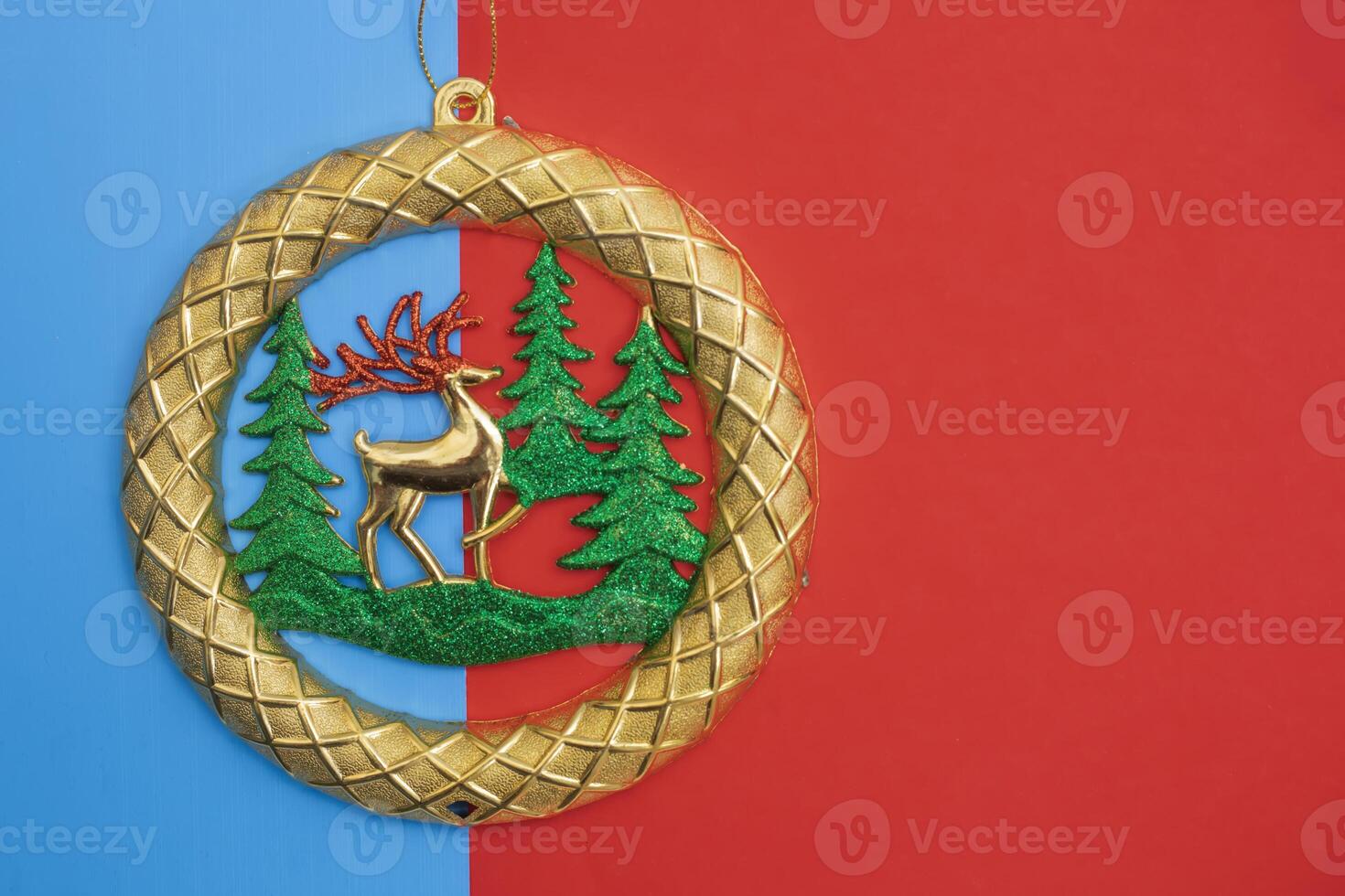 Golden Christmas ornament with reindeer on a red and blue background photo