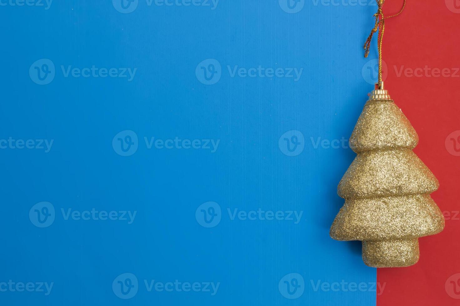 Golden Christmas tree ornament against a blue and red colorful background photo