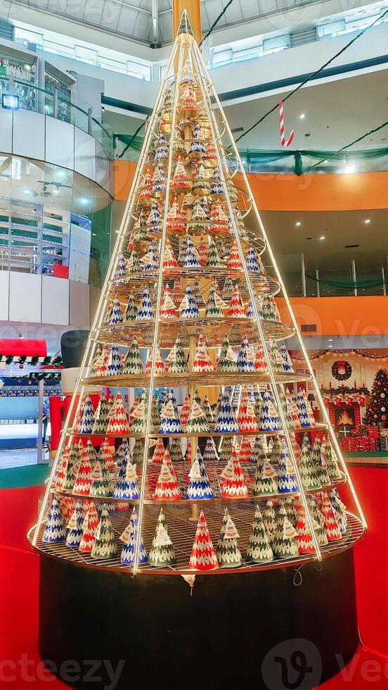 A stunning Christmas tree with colorful triangular decorations and lights displayed inside a mall, creating a festive holiday atmosphere photo
