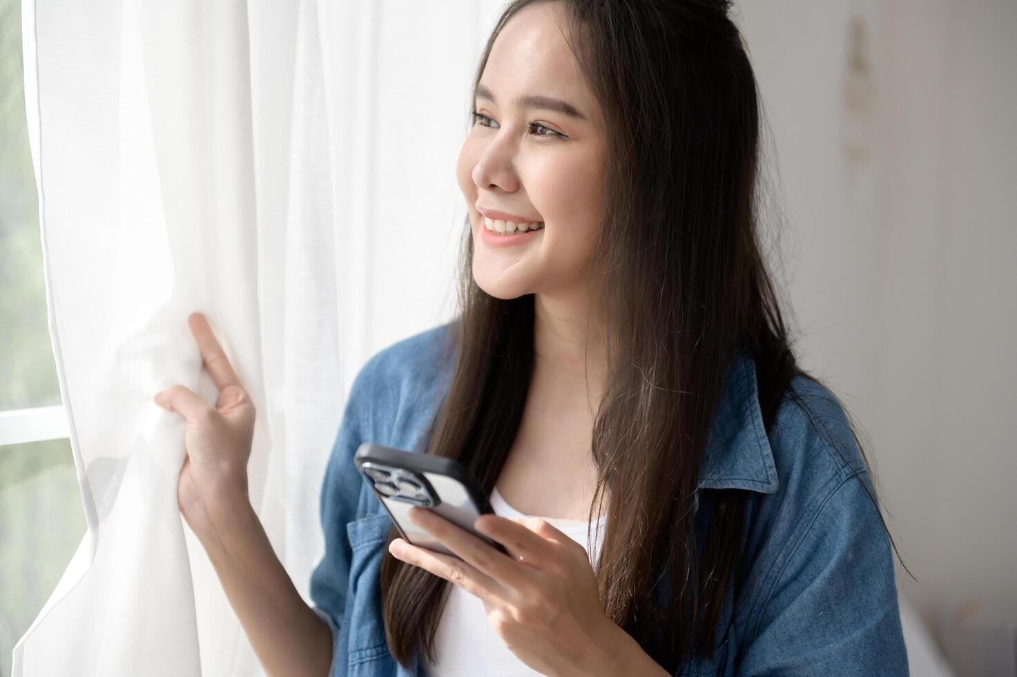 Young Asian woman enjoy using smartphone at home photo