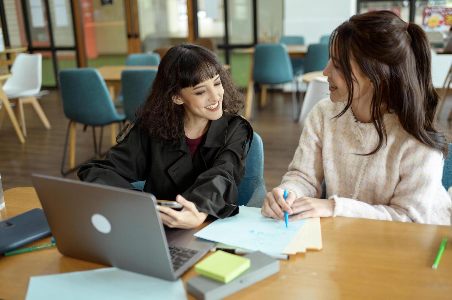 Friends Studying Together at a Cafe Working on Academic Projects photo