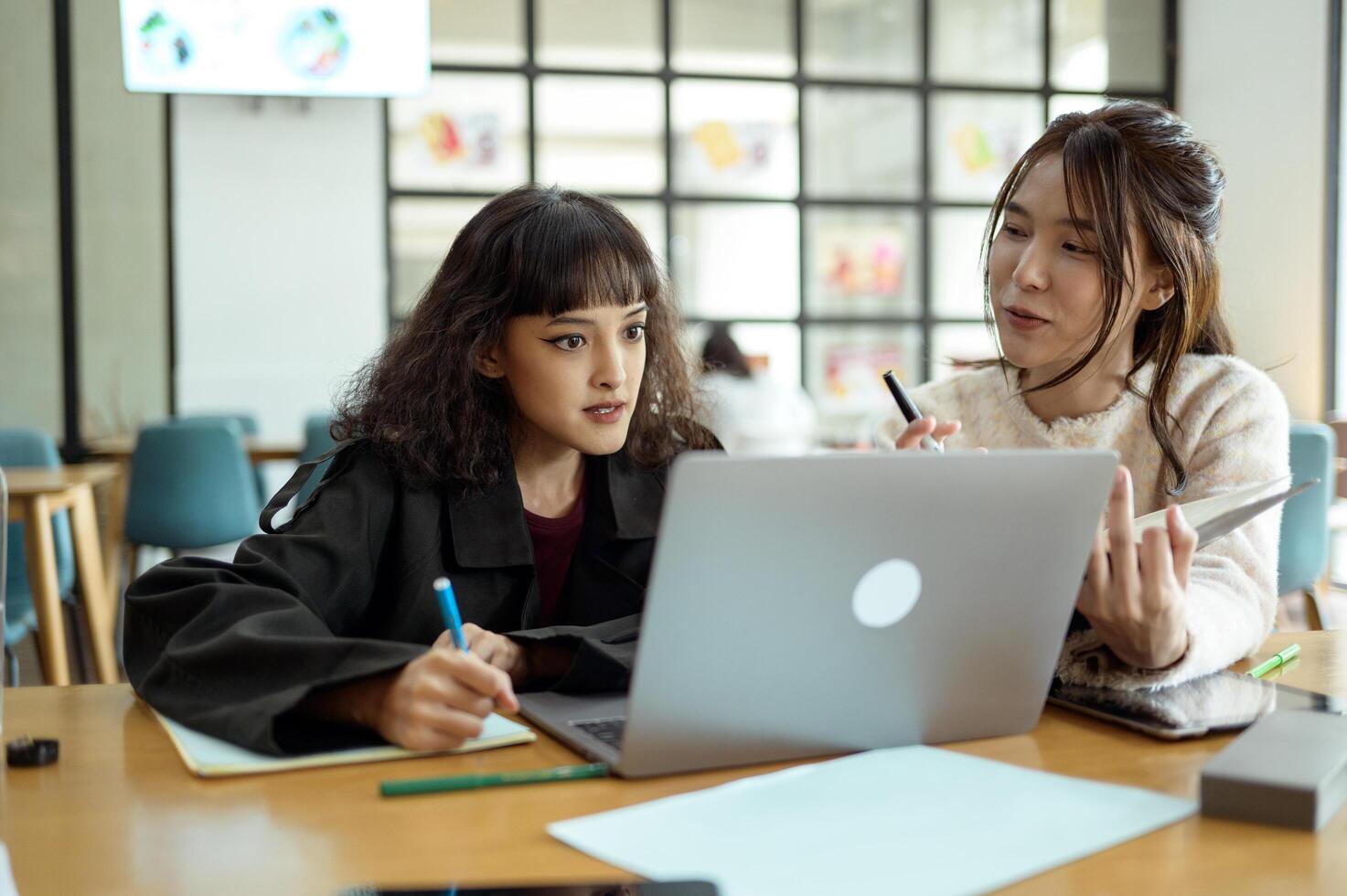 Friends Studying Together at a Cafe Working on Academic Projects photo
