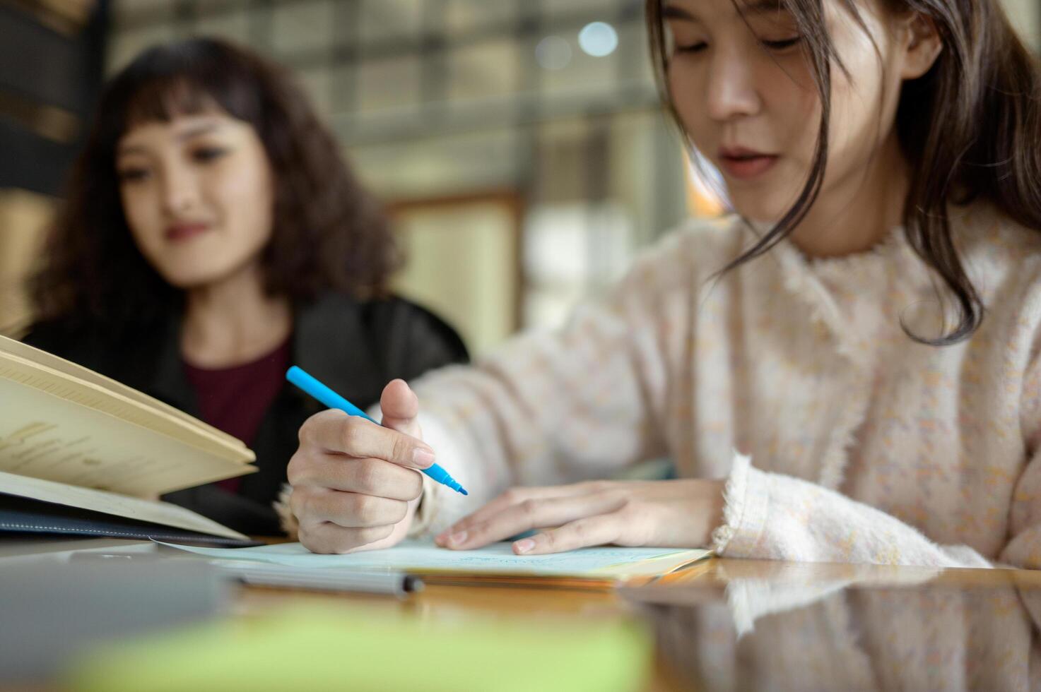 Friends Studying Together at a Cafe Working on Academic Projects photo