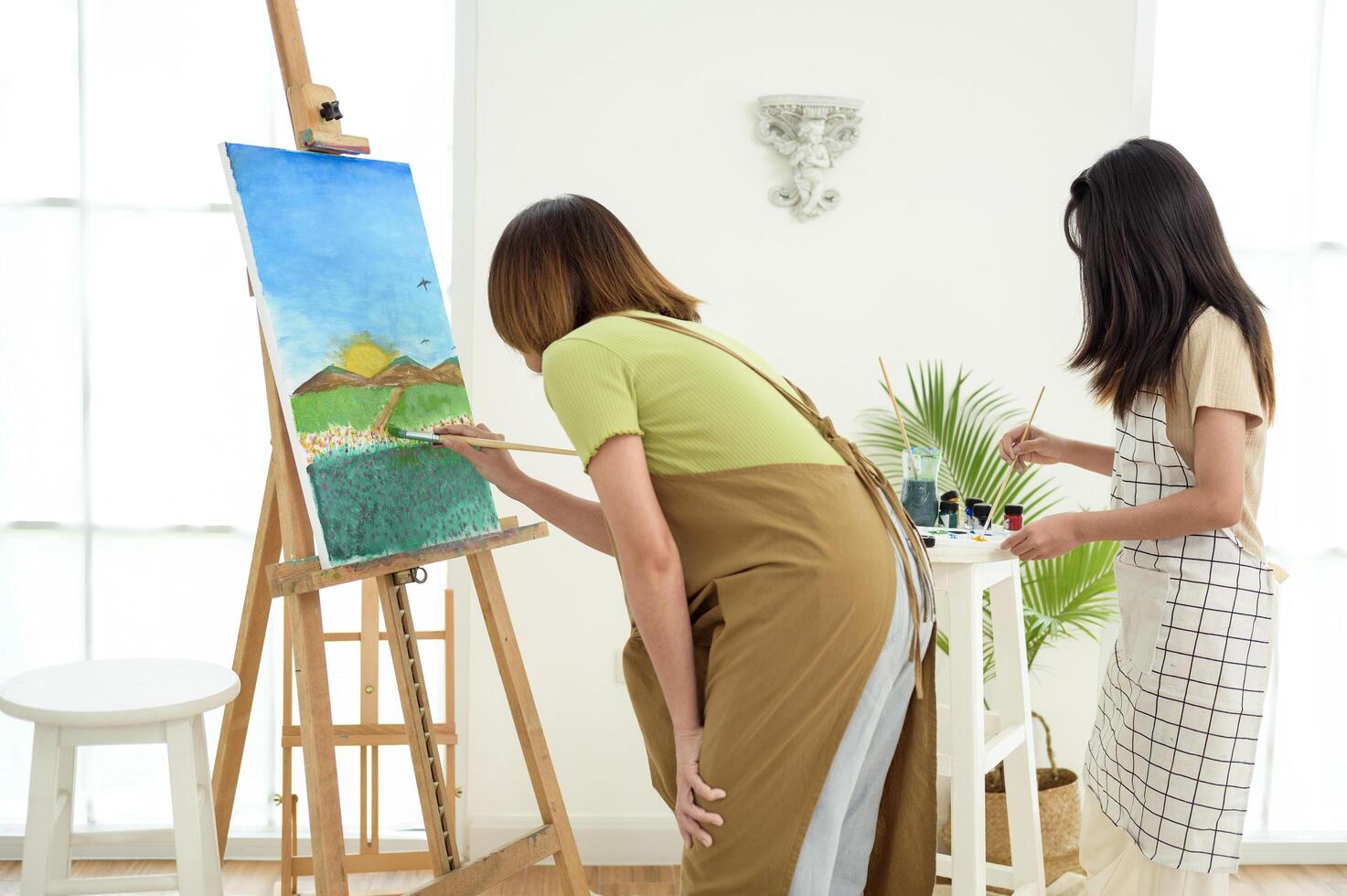 Two young Artists Creating Beautiful Landscape Paintings in a Bright Studio photo