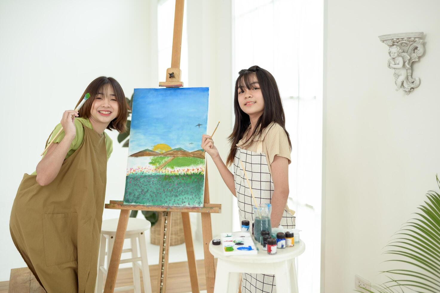 Two young Artists Creating Beautiful Landscape Paintings in a Bright Studio photo