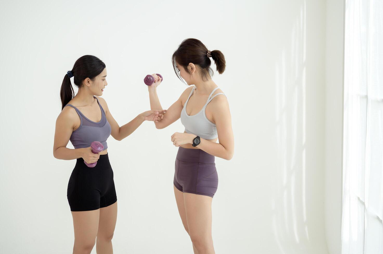Two young Asian sporty woman enjoy workout at studio gym photo