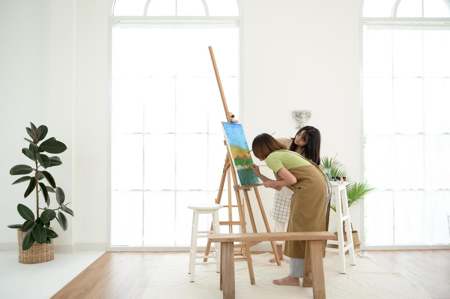 Two young Artists Creating Beautiful Landscape Paintings in a Bright Studio photo