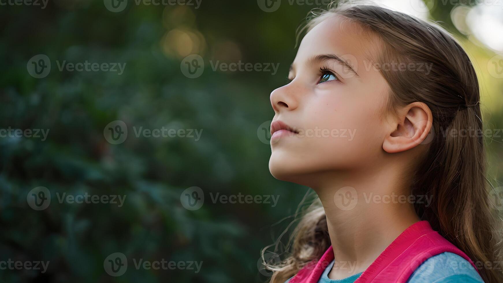 Hopeful Young Girl Gazing Upwards in Nature photo
