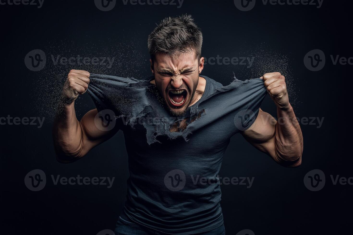 Man tearing t-shirt with force, muscles flexed in intense dramatic action photo
