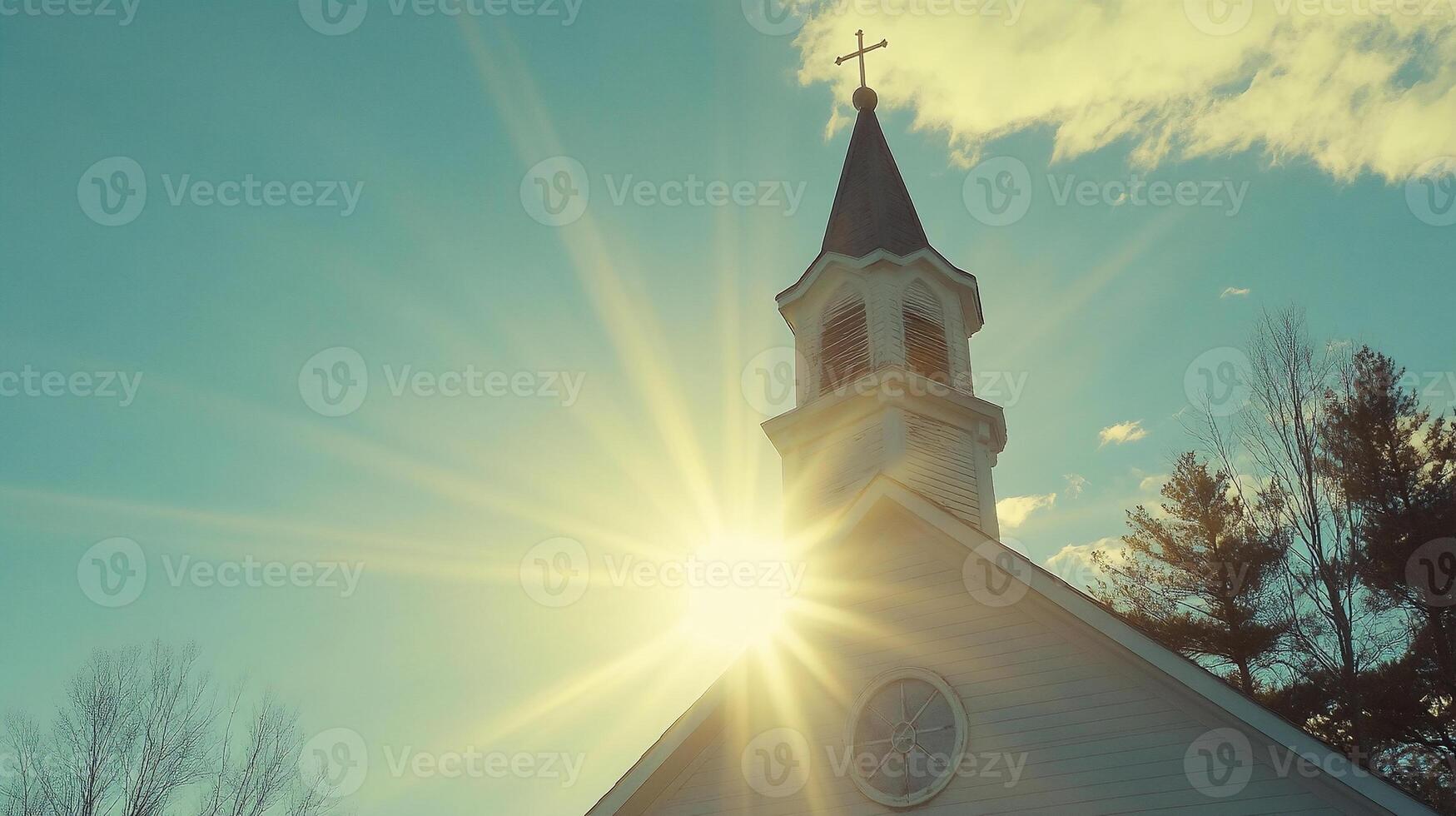 Church Tower with Cross and Sun Behind Creating Lens Flare photo