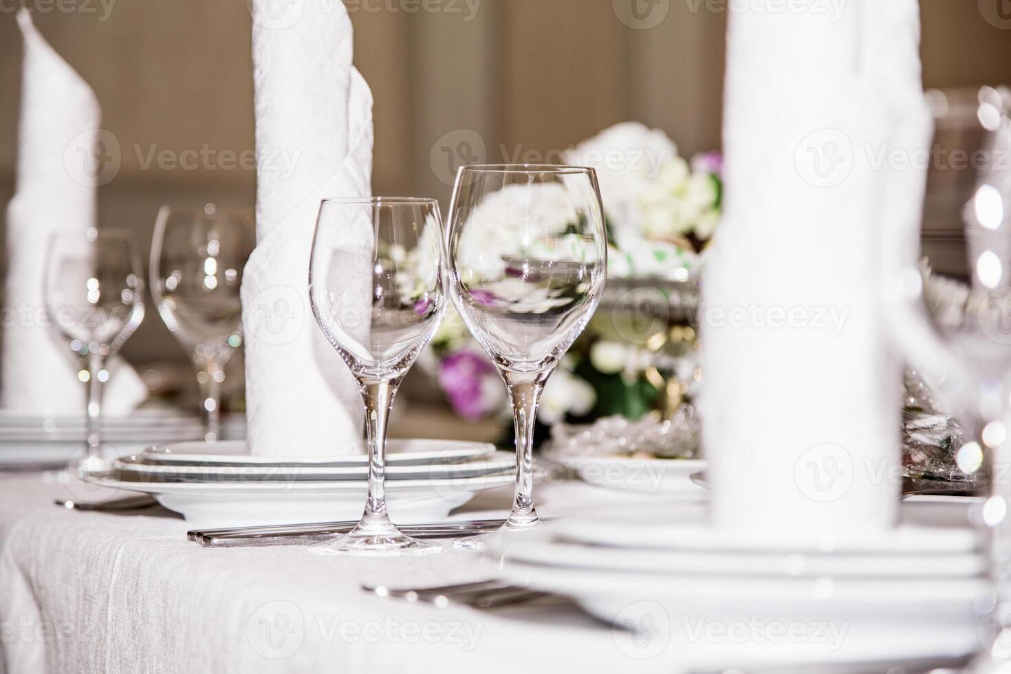 Elegant table setting with folded napkins, wine glasses, and plates, perfect for a formal event or celebration, isolated on a white background. photo
