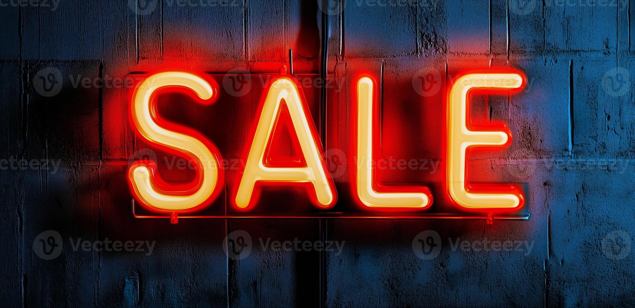 Neon sign displaying the word SALE in bright red and yellow colors against a dark textured wall. photo