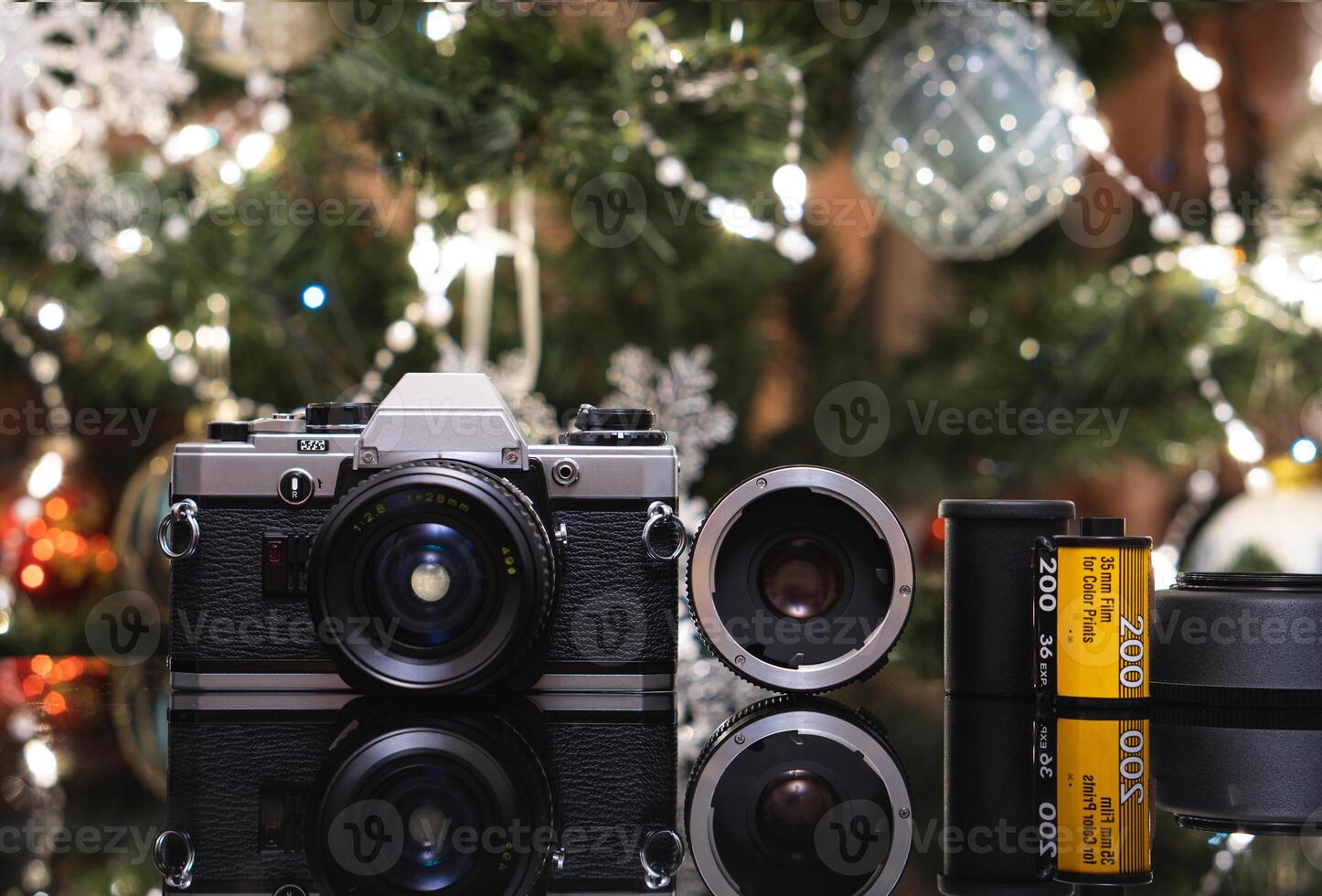 Vintage film camera with a lens and film rolls, set against a festive background. photo