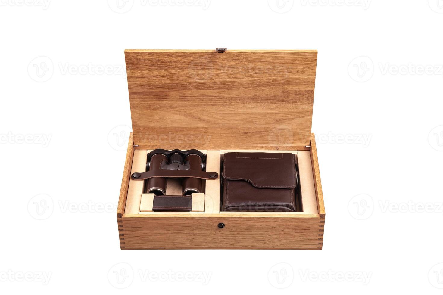 A wooden box with an open lid reveals a set of binoculars and a leather case, both neatly placed in compartments, showcasing a luxurious and organized presentation photo