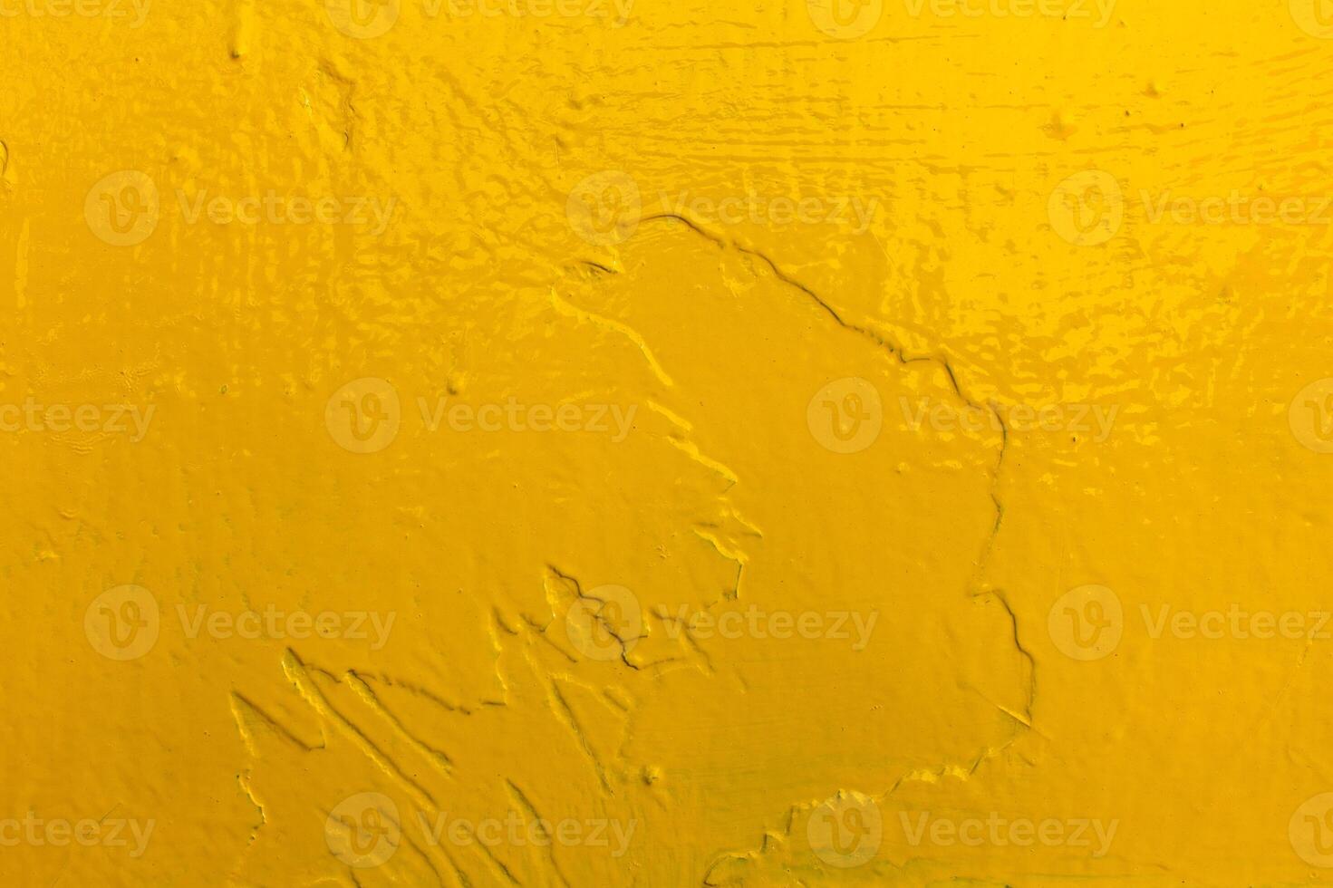 Bright yellow textured surface with visible brush strokes and imperfections, abstract background. photo