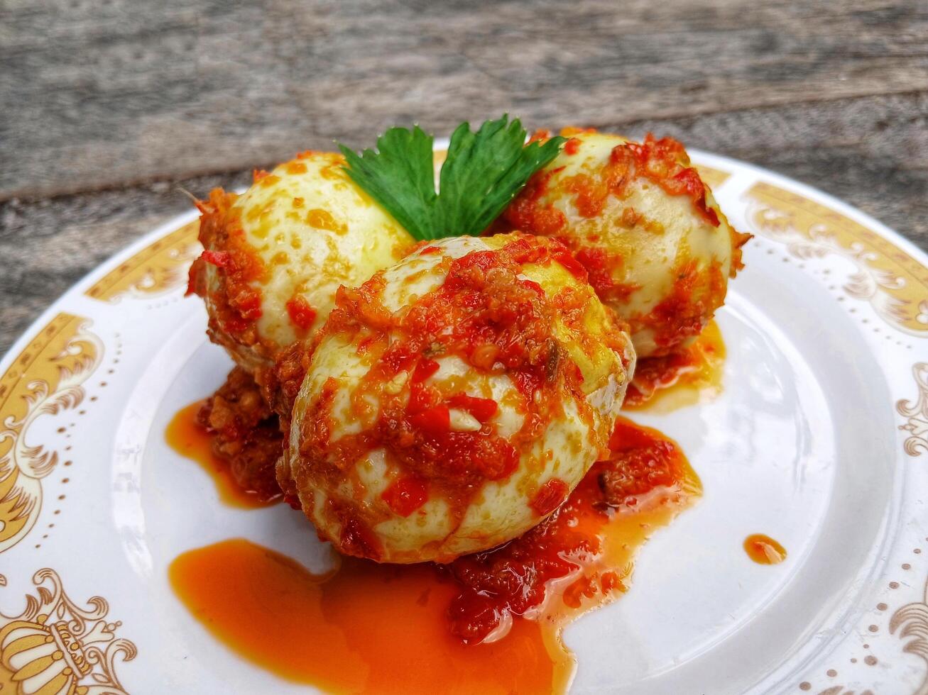 Egg Balado. Balado is a type of hot and spicy bumbu spice mixture found in Indonesian cuisine. Balado sauce is made by stir frying ground red hot chili pepper with other spices photo