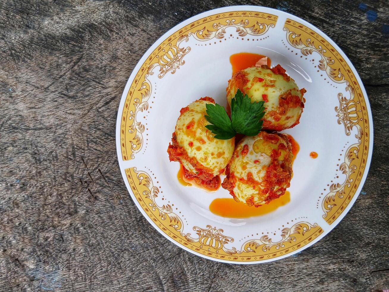Egg Balado. Balado is a type of hot and spicy bumbu spice mixture found in Indonesian cuisine. Balado sauce is made by stir frying ground red hot chili pepper with other spices photo