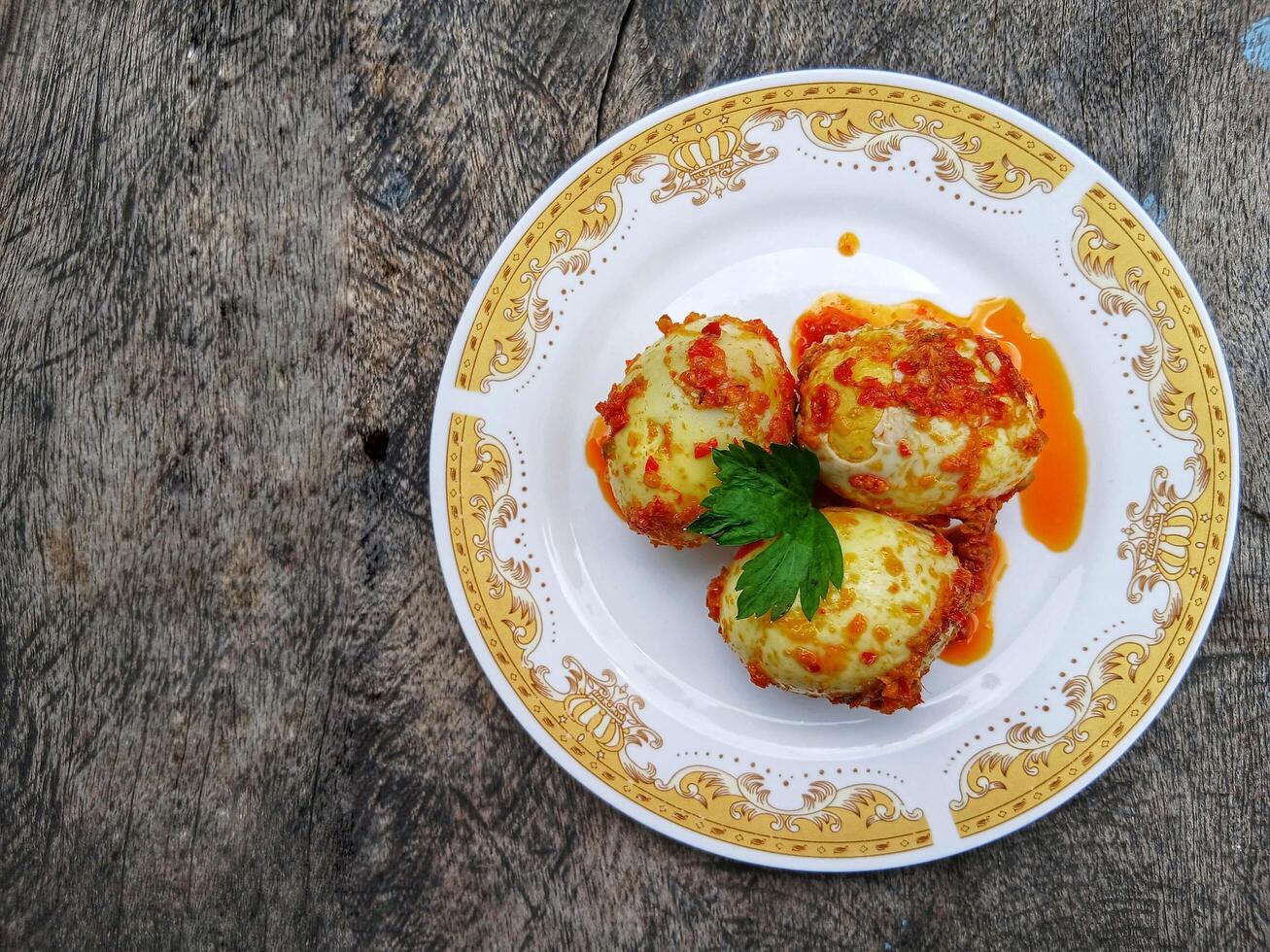 Egg Balado. Balado is a type of hot and spicy bumbu spice mixture found in Indonesian cuisine. Balado sauce is made by stir frying ground red hot chili pepper with other spices photo