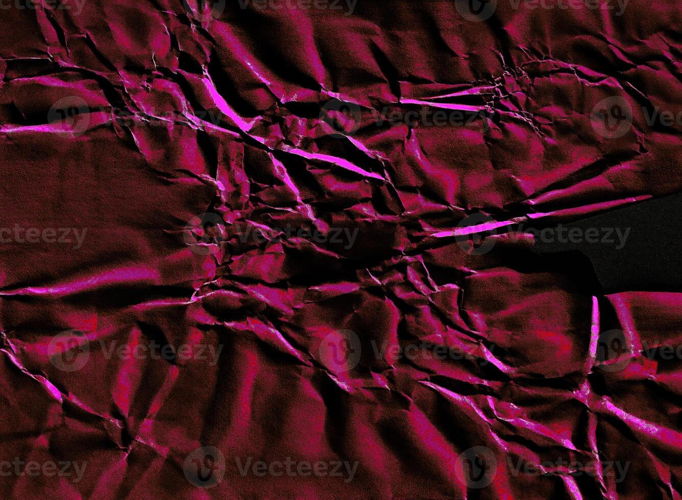 Crumpled paper texture featuring vivid pink highlights and deep black shadows, creating a striking abstract effect. photo