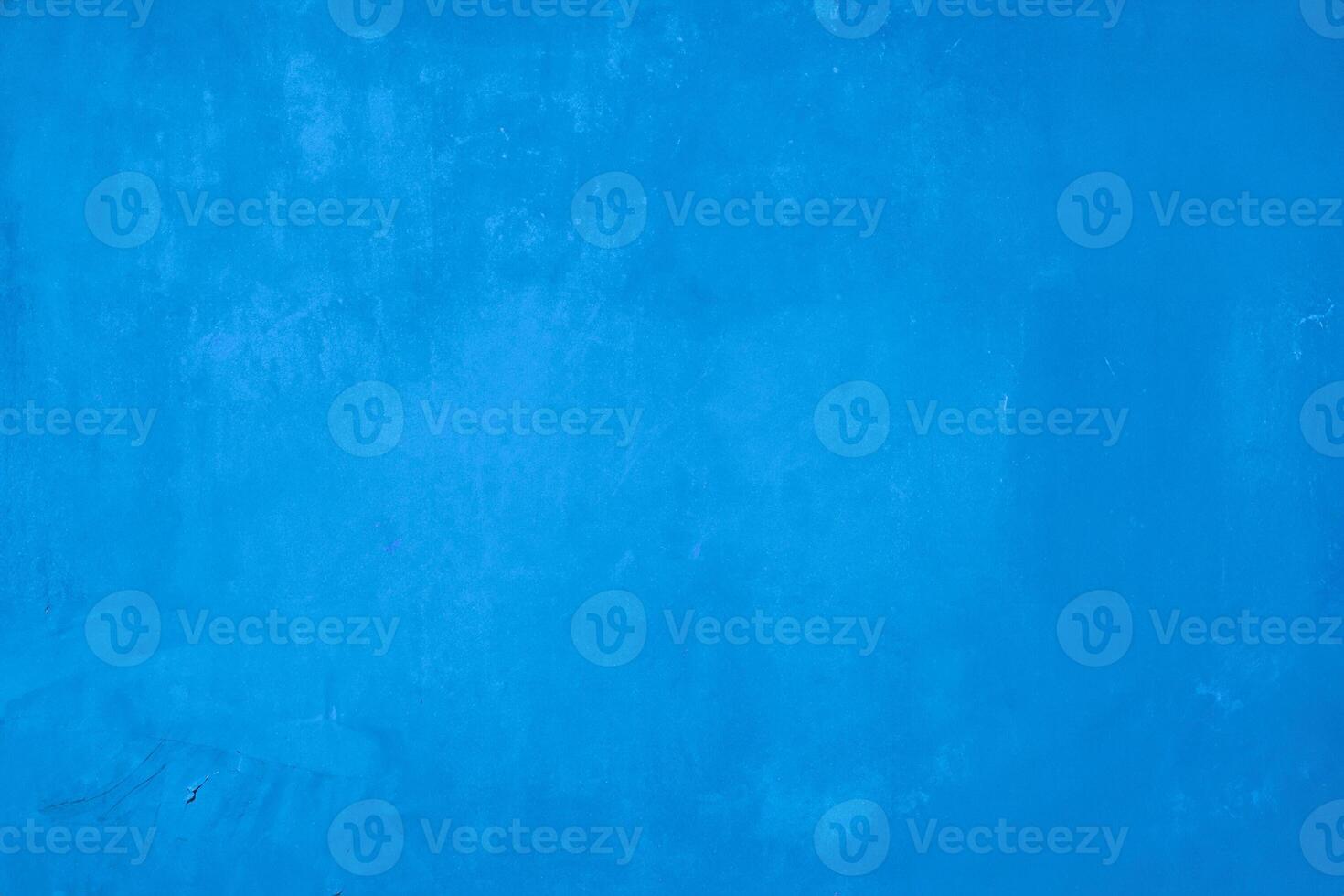 A vibrant blue painted wall with subtle texture, ideal as a minimalist background for creative and design projects. photo