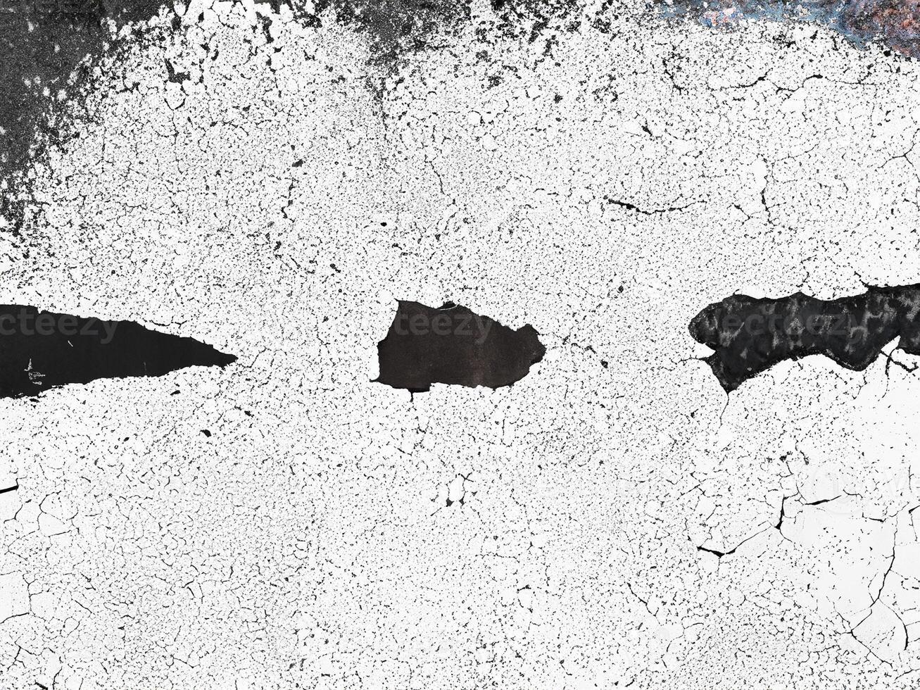 Abstract cracked and weathered surface texture in black and white, featuring rough edges and organic patterns. photo