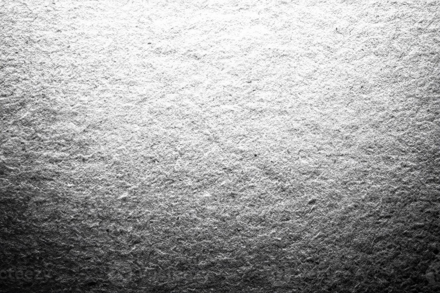 A monochrome close-up of textured paper with soft grain and light gradient, ideal for background and design projects. photo