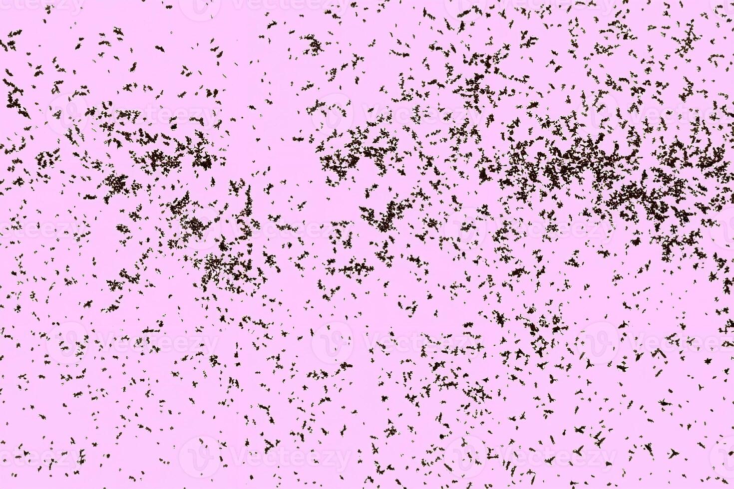 Scattered abstract brown particles on a pink background, creating a unique artistic texture. photo