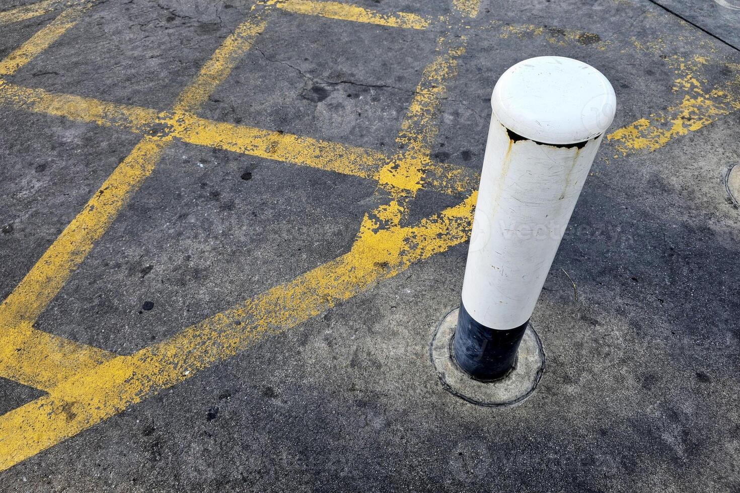 Old Pole with No Parking Yellow Cross Line on the Road. photo