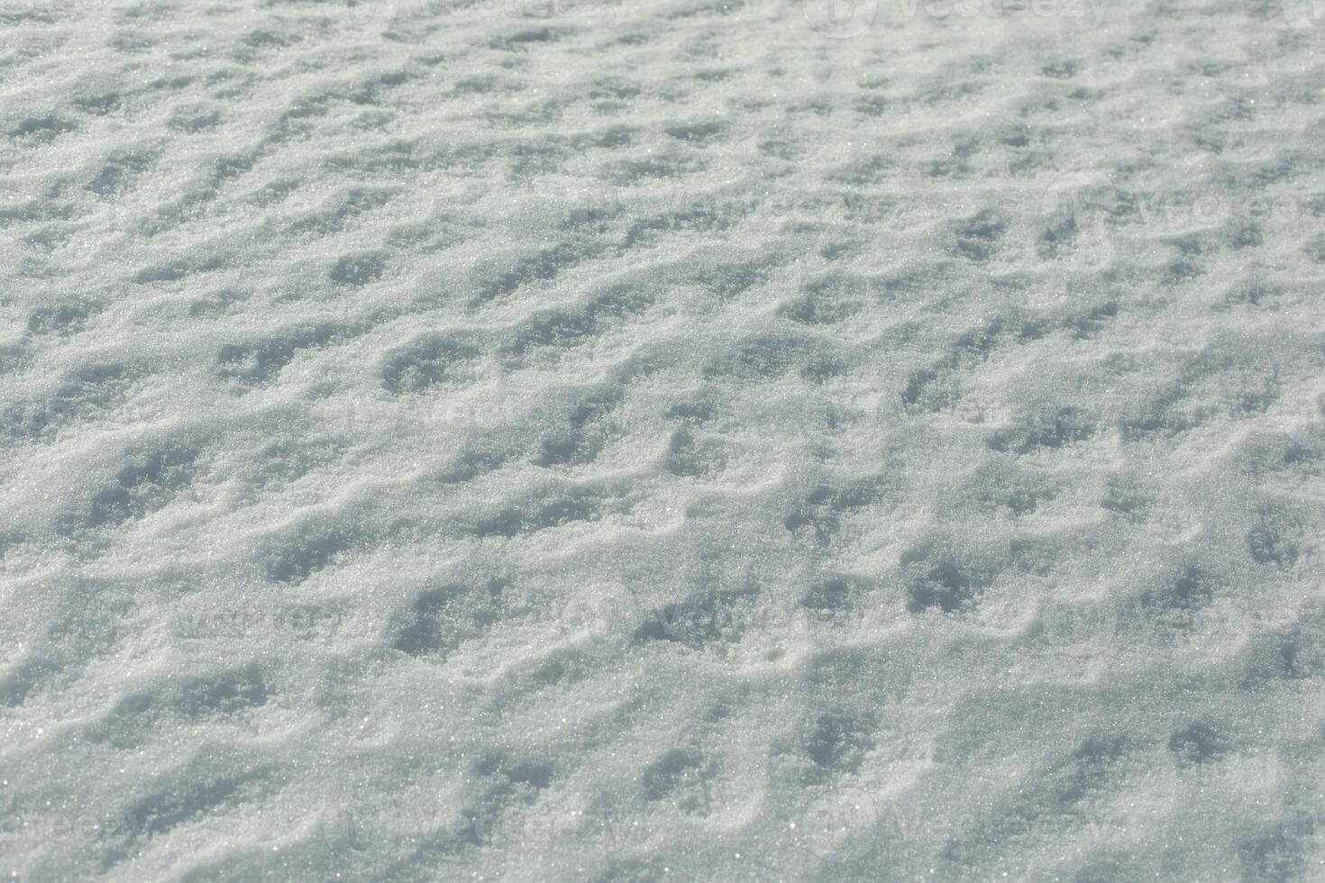 Texture of snow. Melted snow in winter in sun. Surface is wavy. photo