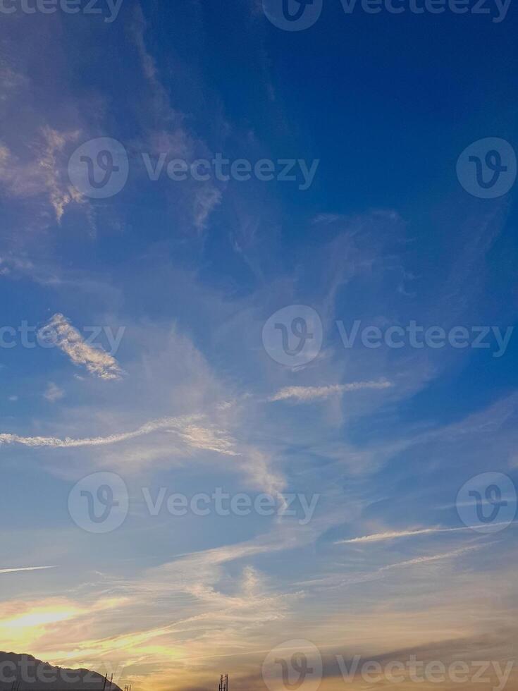 Vibrant cloudscape, where fluffy formations dance across the sky. The sunlight reflects off the soft, billowy clouds, creating a stunning interplay of light and shadow that enhances the vivid colors. photo