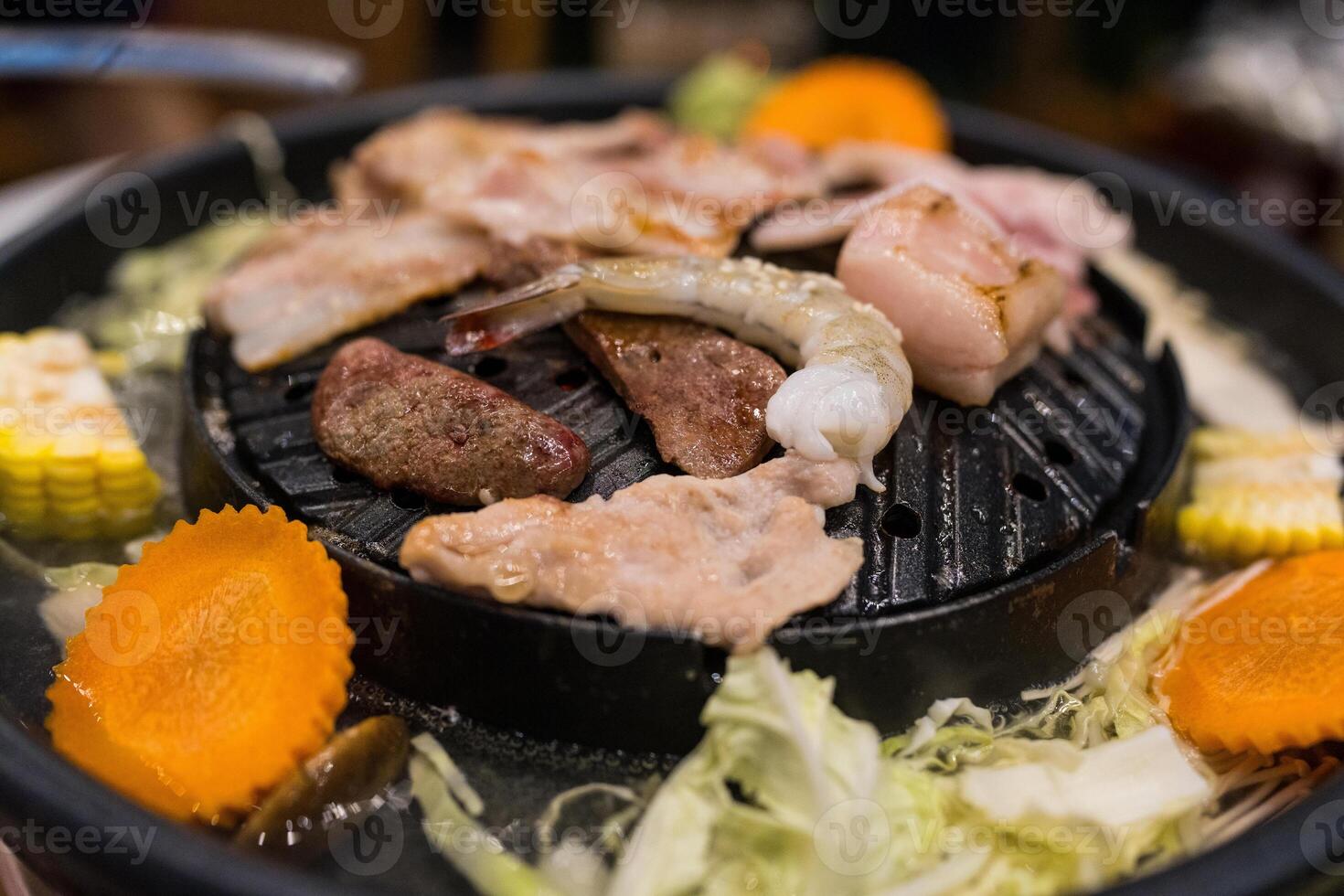 Meat or sea food on the hot pan that can put the soup of vegetable around a pan too. Moo Grata photo
