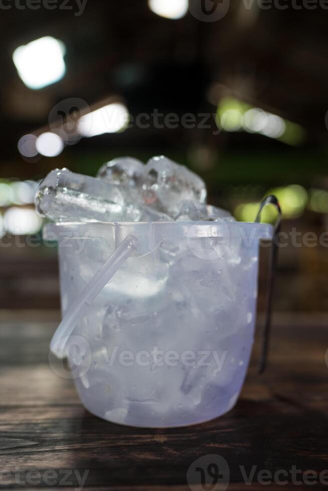 Full of ice cubes in transparent plastic bucket photo