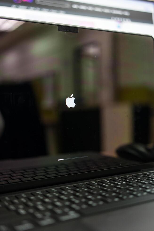 BANGKOK, THAILAND - DECEMBER 30, 2024 Installing Software update left sign on black screen of Apple macBook Pro laptop computer photo