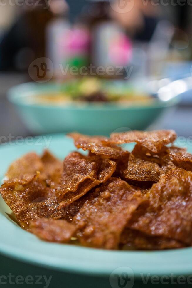 Sliced sheets of dried and crispy pork on dish. photo