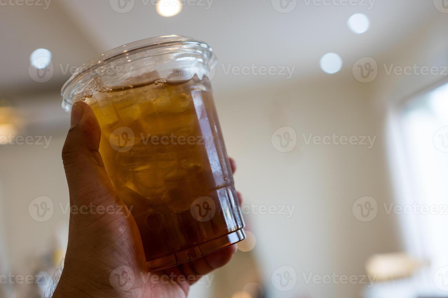 Glass of tasty lemon iced tea on hand photo