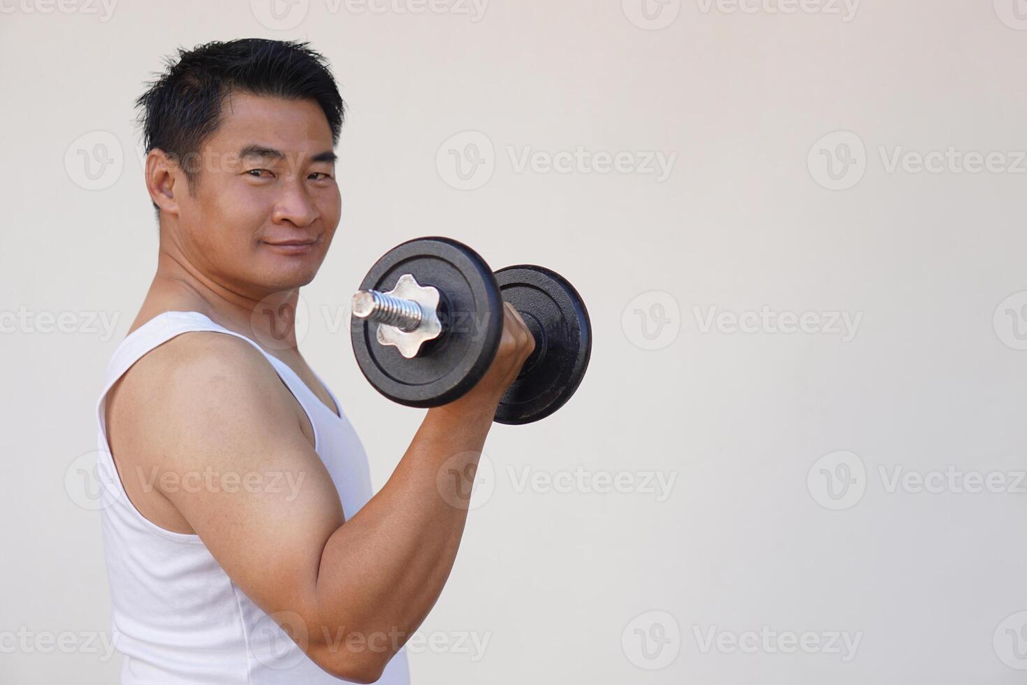 Asian man is lifting dumbbell for exercise. Concept, Exercise for health bodybuilding. Strengthen muscle. Weight lifting. Healthy lifestyle. Sport equipment. Work out makes strong of body. photo