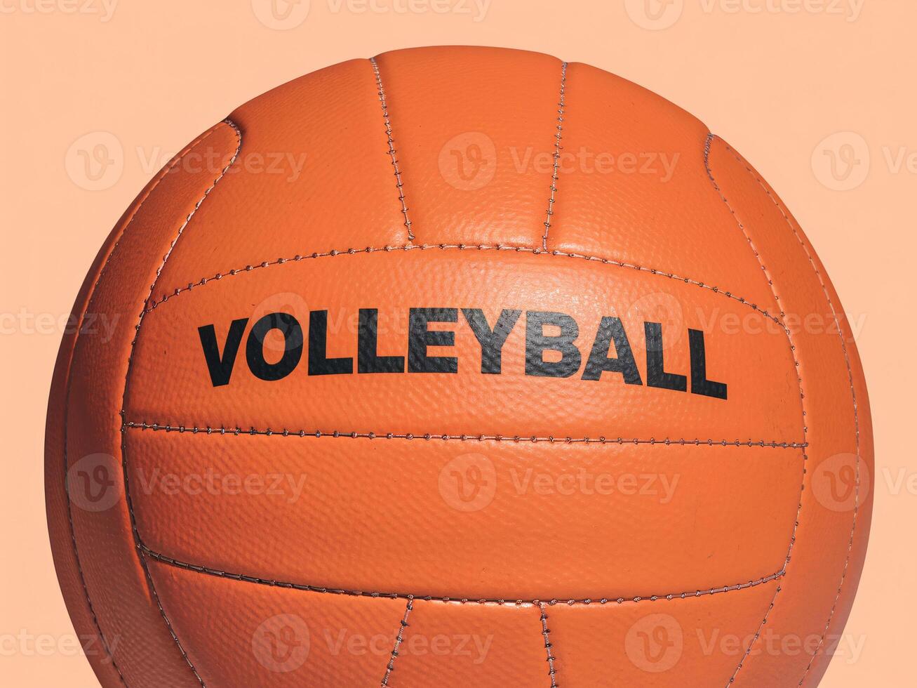 Close-up of an orange volleyball with bold black text against a soft peach background. photo