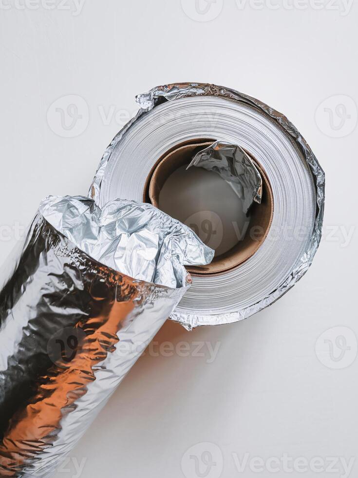 Close-up of a roll of aluminum foil with partially unwrapped layers, showcasing its shiny surface. photo