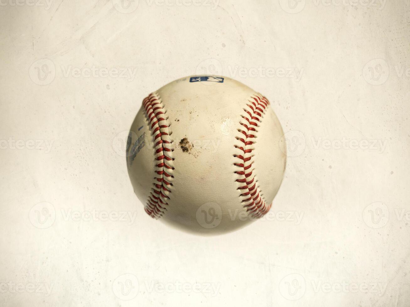 A close-up of a well-worn baseball with visible stitching and dirt marks. photo