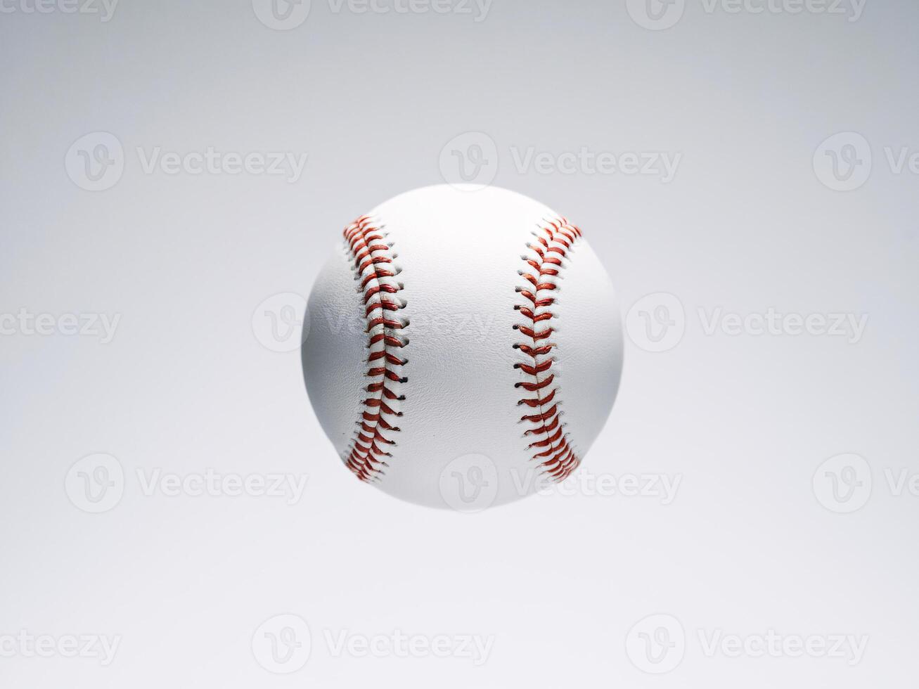 A close-up of a white baseball suspended in mid-air, showcasing its red stitching and smooth surface. photo