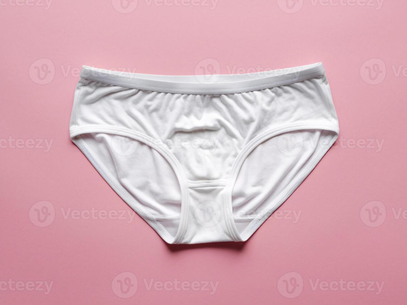White cotton briefs on a soft pink background, showcasing simplicity and comfort. photo