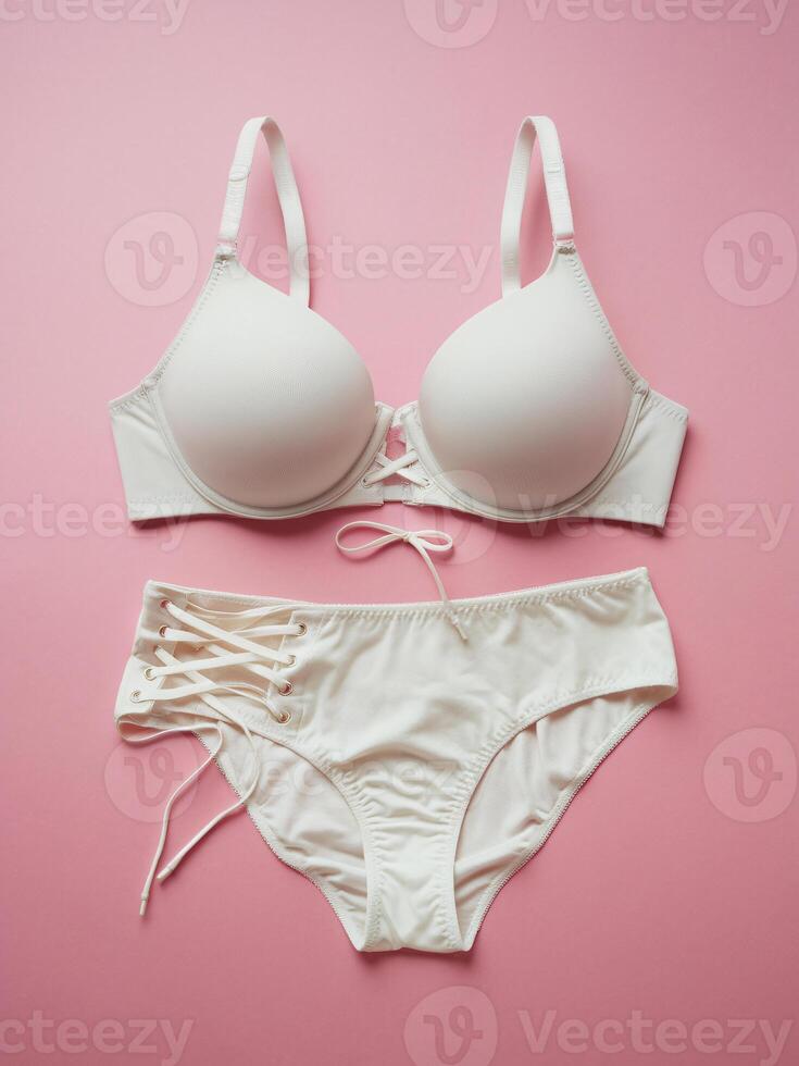 Stylish white lingerie set on a soft pink background, featuring modern design and delicate details. photo