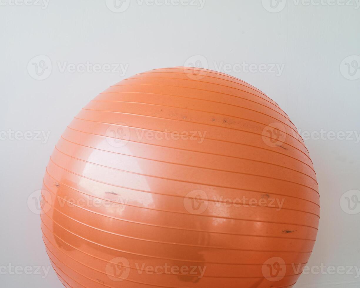 An orange exercise ball on a white background, perfect for fitness and stability workouts. photo
