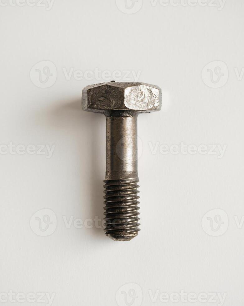 Close-up of a metallic bolt showcasing its hexagonal head and threaded shaft. photo