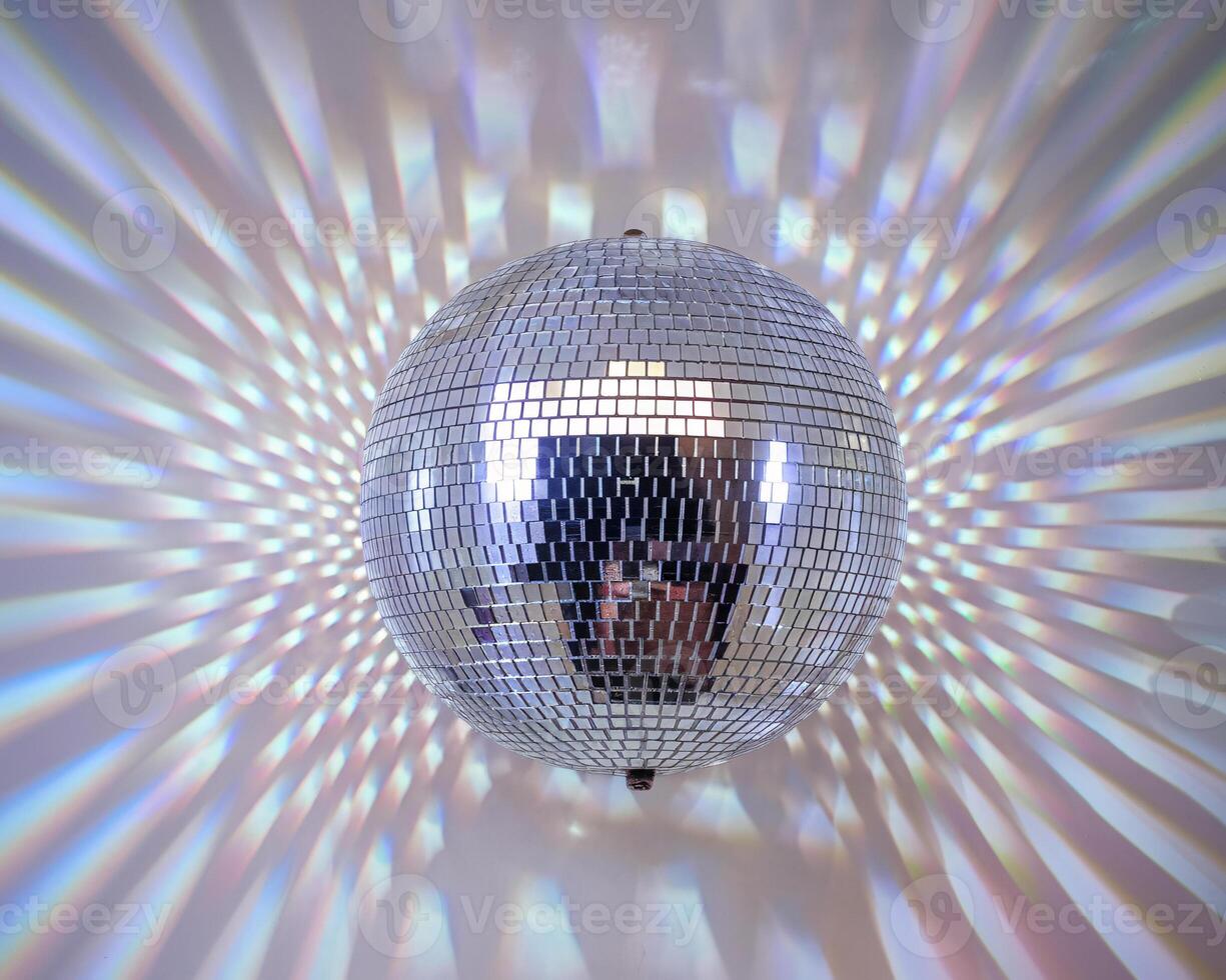 A dazzling silver disco ball reflecting vibrant light patterns on a wall. photo