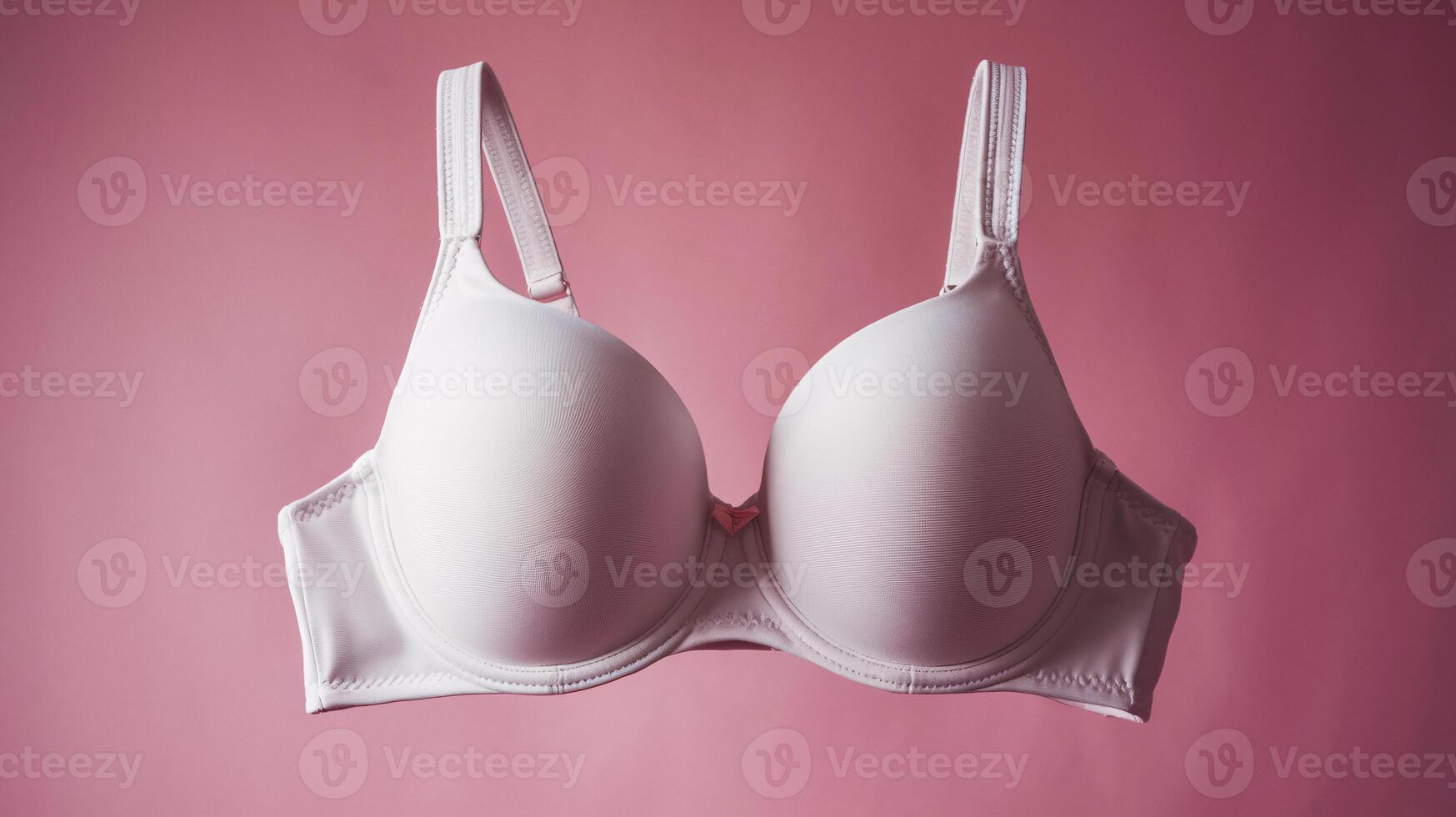 Elegant white bra against a soft pink background, emphasizing comfort and style. photo