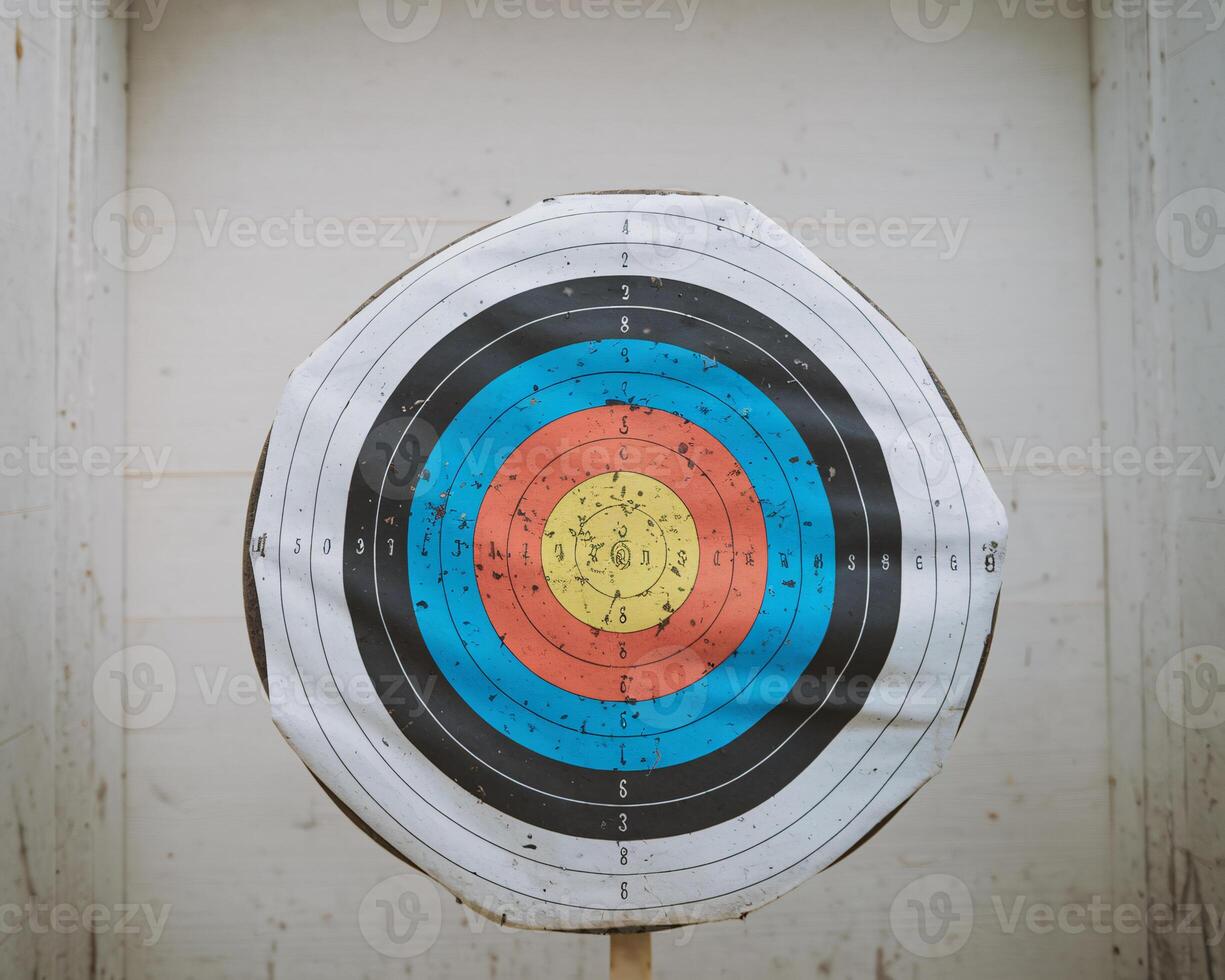 A colorful archery target displaying multiple scoring zones, with visible wear and marks. photo