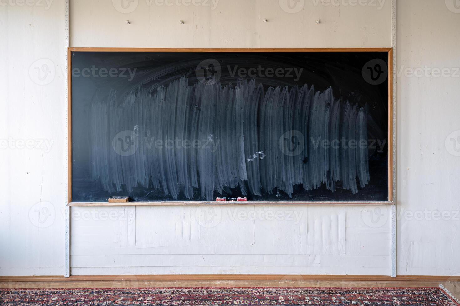 A clean black chalkboard in a bright classroom setting, ready for new lessons. photo